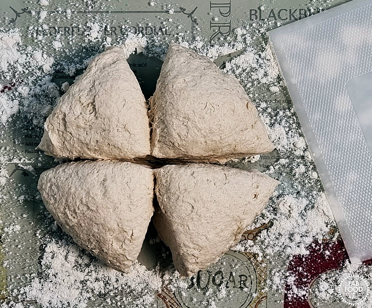 Easy Spelt Yogurt Flatbread dough cut into 4 equal pieces with a dough cutter.