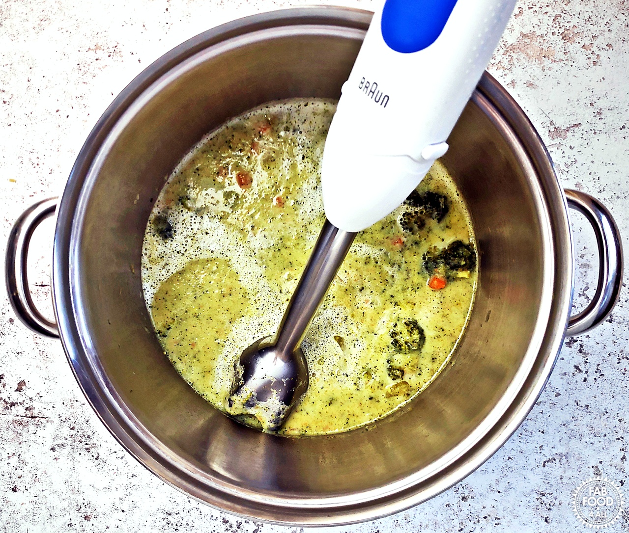 Blending Broccoli Cheddar Soup with a stick blender.
