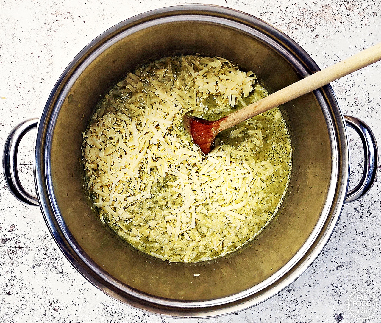 Grated cheese added to the pan of soup.