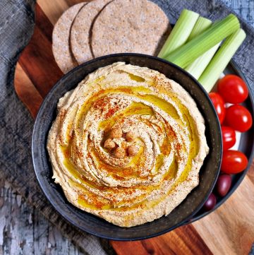 Quick Homemade Hummus Recipe in a bowl with crudite and crackers aerial shot.