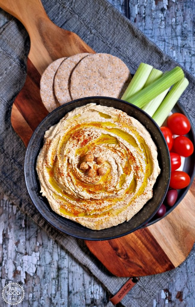 Quick Homemade Hummus Recipe in a bowl with crudite and crackers aerial shot.
