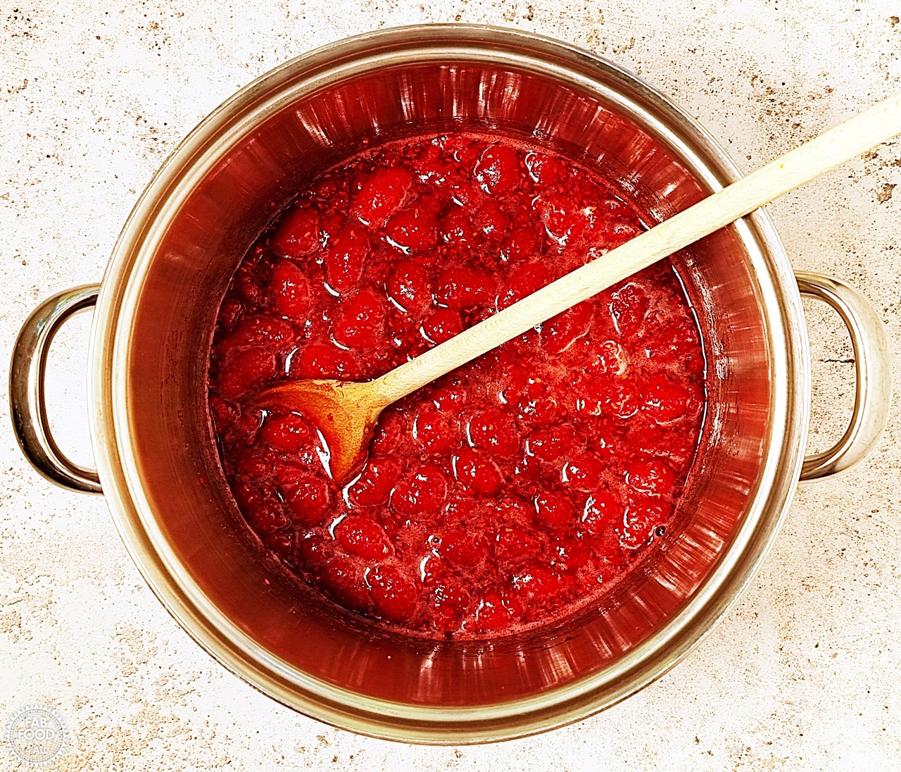 Shot of pan where the sugar has melted and the raspberries have cooked down a little.