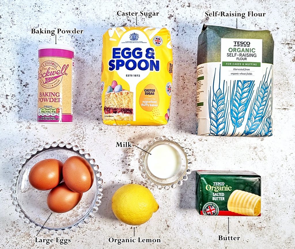 Lemon Drizzle Traybake Ingredients: left to right - Baking Powder, Caster Sugar, Self-Raising Flour, Large Eggs, Organic Lemon, milk and butter.