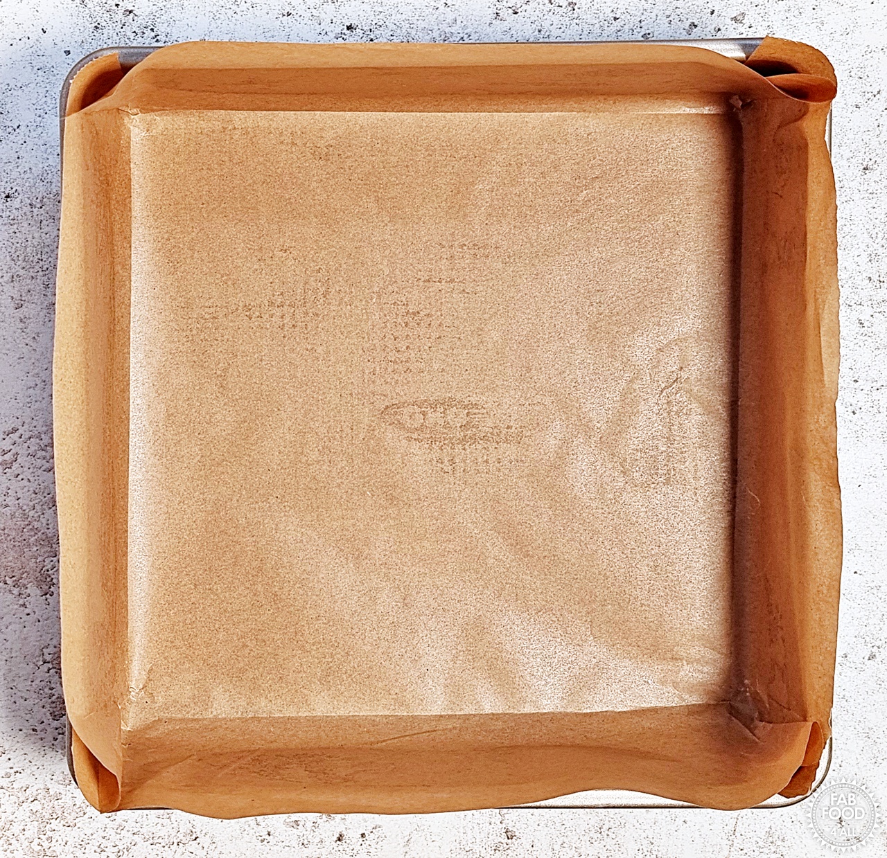 Square baking tin lined with unbleached baking parchment.