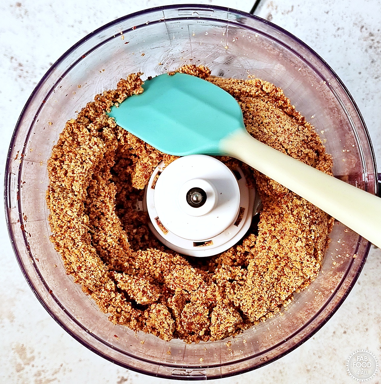 Scraping down the sides of the food processor with a rubber spatula when blended peanut mixture is grainy and seizes.