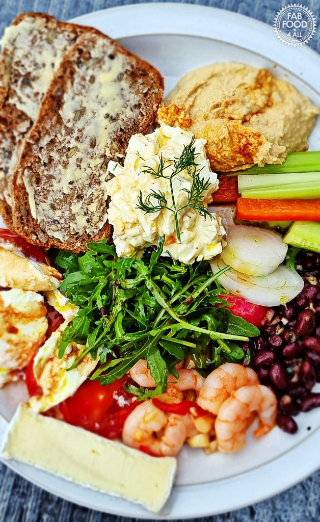 Healthy Egg Salad with Greek Yogurt served on a plate with other cold food and green salad.