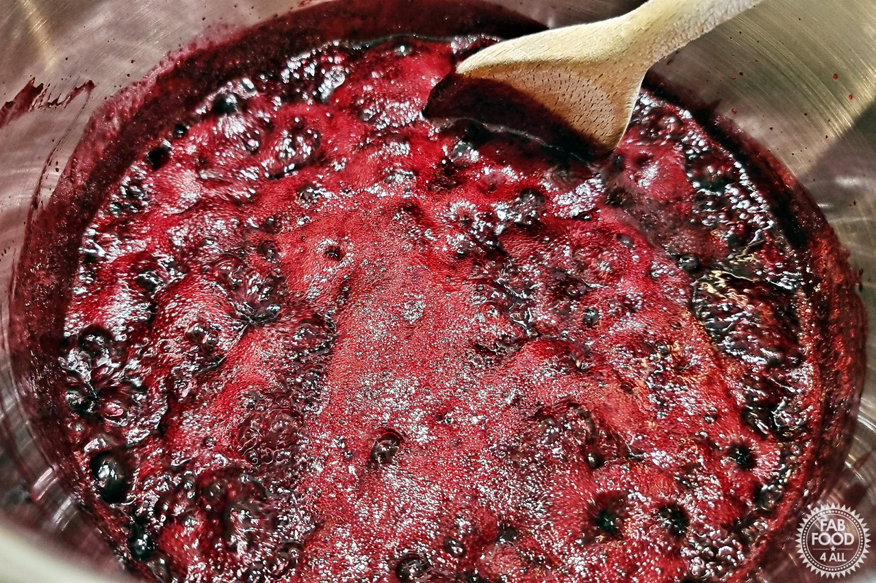 Seedless Blackberry & Raspberry Jam in a larege stainless steel pot on a rolling boil.