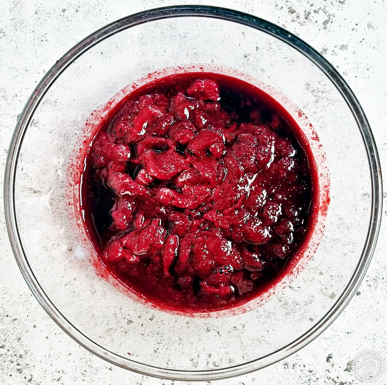Cooked blackberry and raspberry pulp/juice in a glass bowl (after sieving).