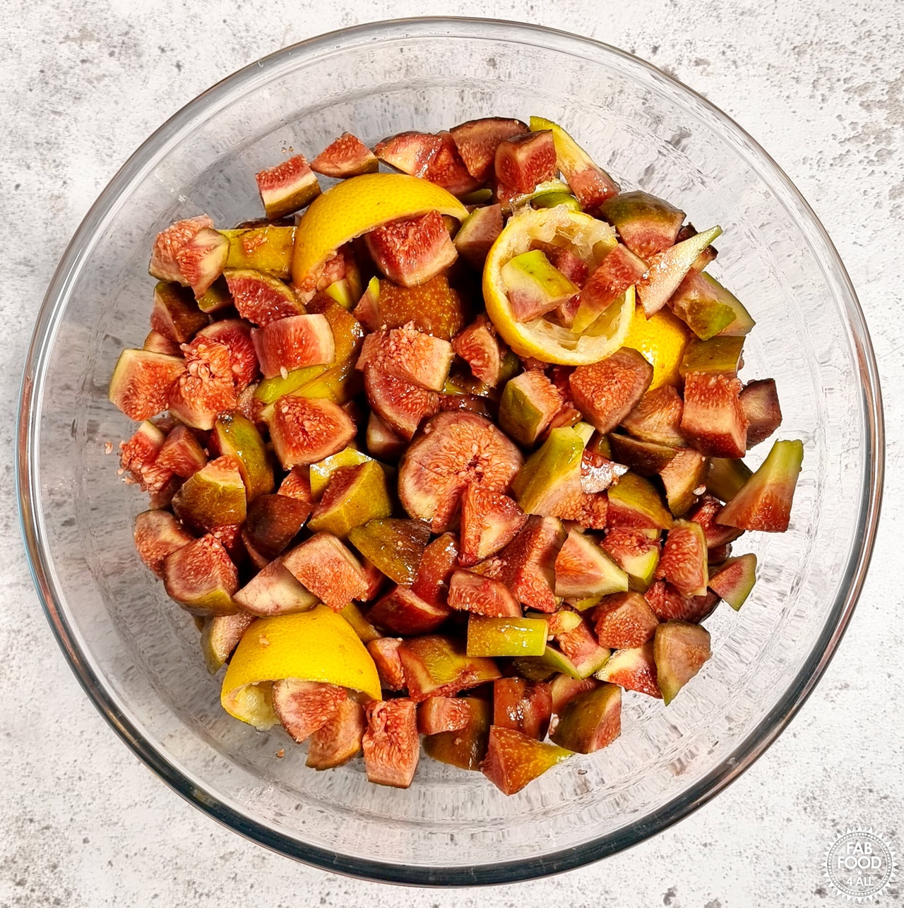 Chopped figs and lemon rinds in a glass bowl.