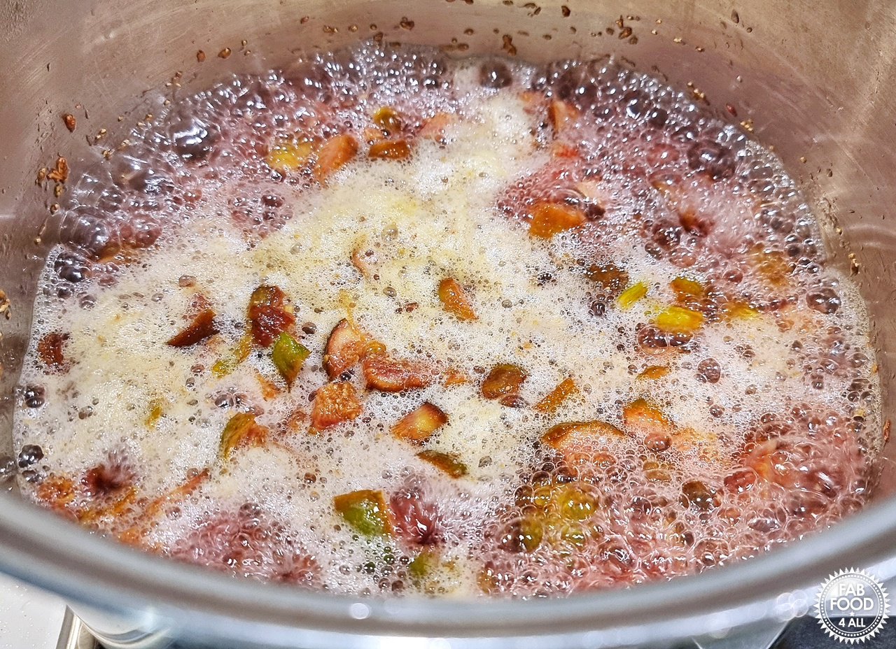 Fig Jam mixture on a full rolling boil in a large stainless steel pan.