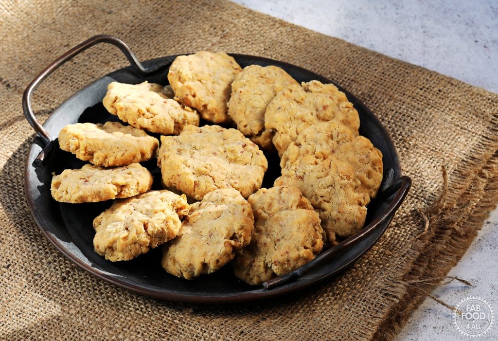 Landscape shot of Savoury Spelt Cookies with Cheddar and Peanut Butter on a metal serving dish on a hessian cloth.