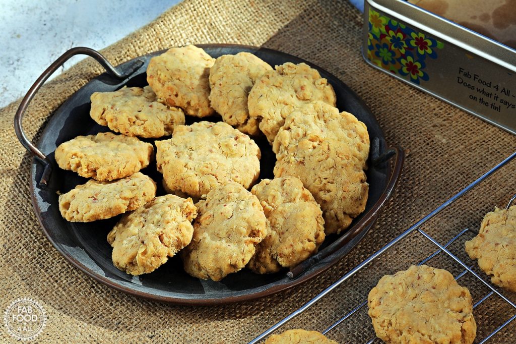 Metal dish of Savoury Spelt Cookies with Cheddar & Peanut Butter with cake tin and wire rack just visible.